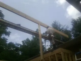 Carpenter setting a ridge beam over a new addition frame — Ice Dam Removal by Roofing Brothers in Sallisaw