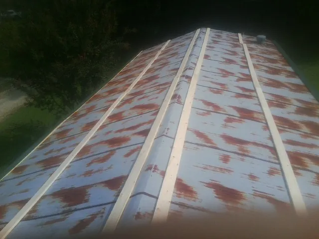 Rusted metal roof panels with new wood purlins before replacement — Storm Damage Roof Repair in Sallisaw by Roofing Brothers
