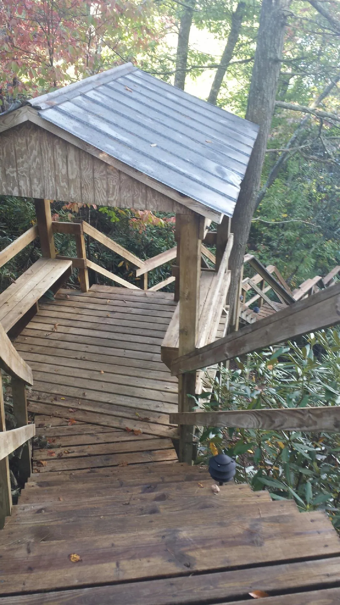 Metal roofed shelter over wooden steps on a wooded walkway — Skylight Repair & Installation work by our crew in Sallisaw