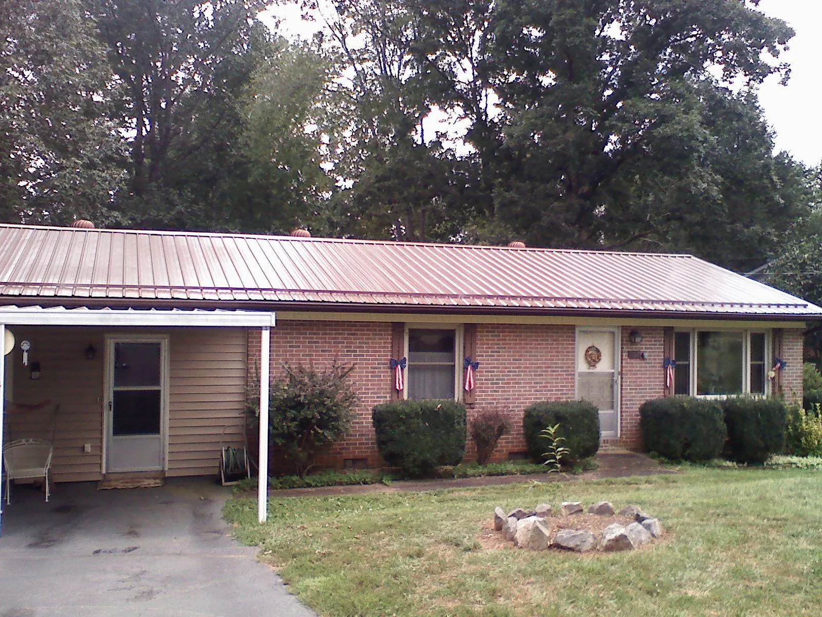 Bronze metal roof and carport on a brick ranch home — Roof Repair work by our crew in Sallisaw