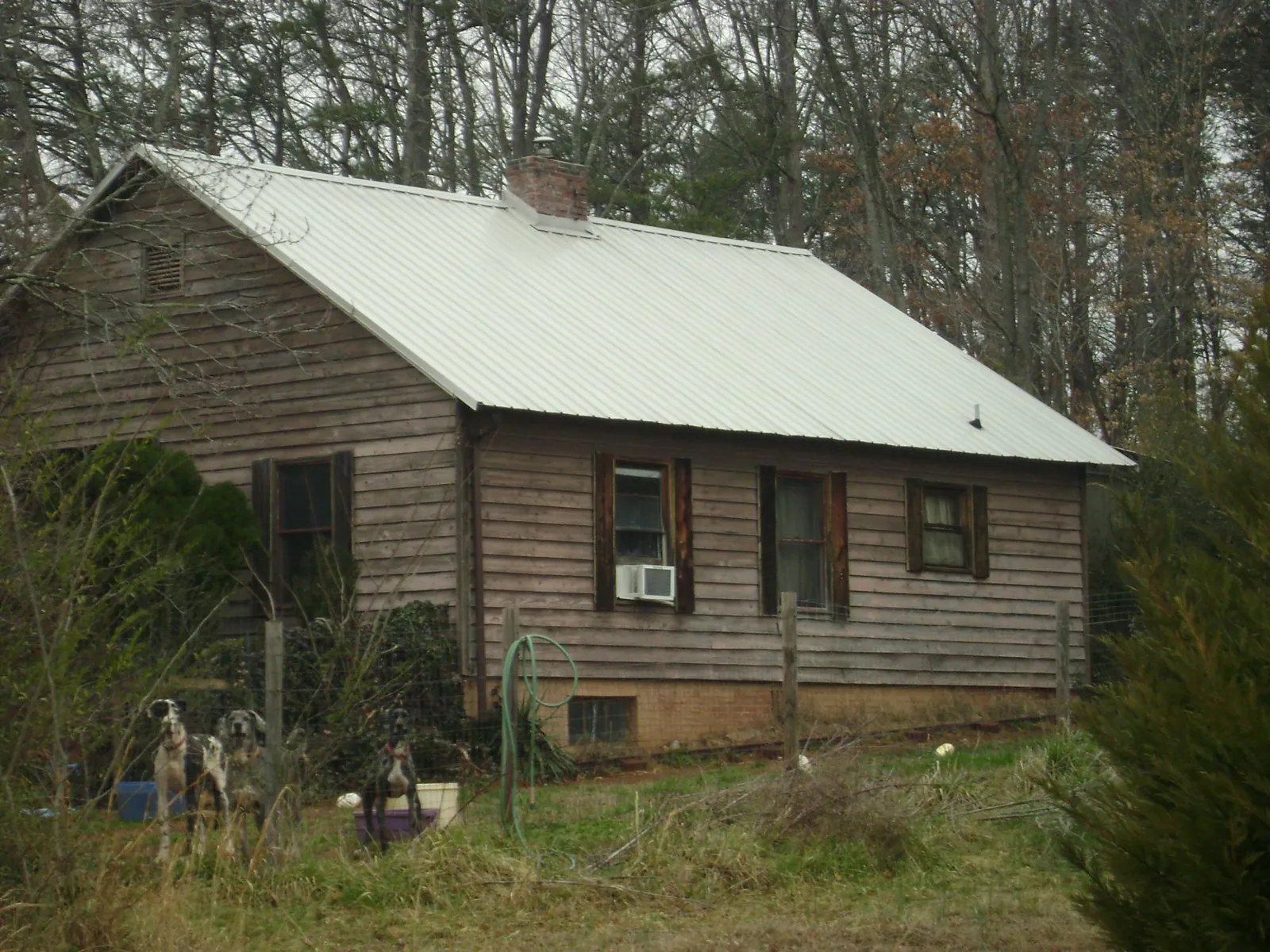 White metal roof on an old wood sided farmhouse, from a Asphalt Shingle Roof Repair job in Sallisaw